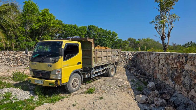 Un camion transportant du matériau pour la Rumah Kambera construction de sirtu arrive sur le chantier Kawangu à East Sumba.
